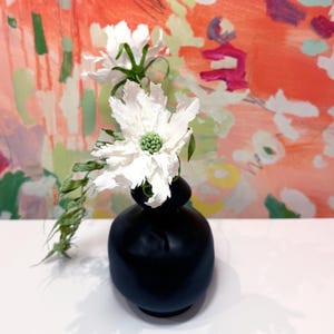 Scabiosa flowers with knotted palm frond crepe paper flowers and vase