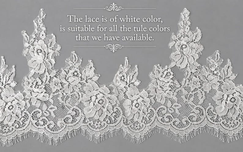 May include: A white lace trim featuring an intricate floral pattern with scalloped edges. The text on the image reads: The lace is of white colour, is suitable for all the tule colours that we have available. The lace has a delicate, openwork design.