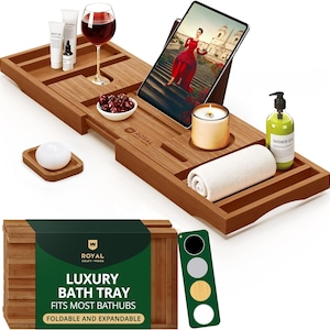 May include: A brown bamboo bath tray with compartments for a tablet, wine glass, and toiletries. The tray holds a tablet displaying a woman in a red dress, a lit candle, and a rolled white towel. The packaging reads "LUXURY BATH TRAY FITS MOST BATHUBS FOLDABLE AND EXPANDABLE."