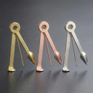 Può includere: Tre strumenti per pipe in metallo dorato, ramato e argentato. Ogni strumento ha un'impugnatura circolare, un punteruolo e un alesatore conico. Gli steli sono decorati con un motivo ripetuto.