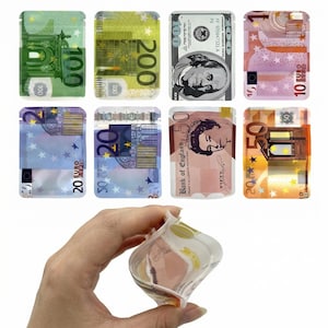 May include: A selection of transparent, resealable bags printed with designs of different international banknotes, including Euros, US dollars, and British pounds. The bags are held in a hand, displaying the range of currencies.