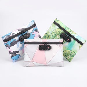 May include: Three zippered pouches with black combination locks. One has a blue and white camouflage pattern, another a geometric design in pink, white, and grey, and the third features a lime slice print.