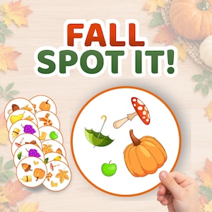 May include: A Fall Spot It! game featuring circular cards with autumn-themed illustrations including pumpkins, mushrooms, umbrellas, grapes, and leaves. The game includes a large circular card displaying a green umbrella, a red mushroom, a green apple, and an orange pumpkin, alongside a stack of smaller matching cards.