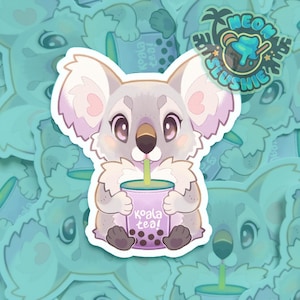May include: A sticker featuring a cartoon koala drinking from a purple cup of boba tea. The koala is gray with pink accents and large eyes. The cup reads "Koala Tea!" and the sticker has a "Neon Slushie" logo.