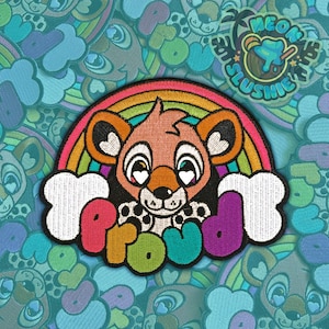 May include: Embroidered patch with a cartoon lion cub, rainbow, and the word "PROUD" in vibrant colours. The patch includes a white cloud design and a "Neon Slushie" logo. The background is a repeating pattern of cartoon characters and rainbows.