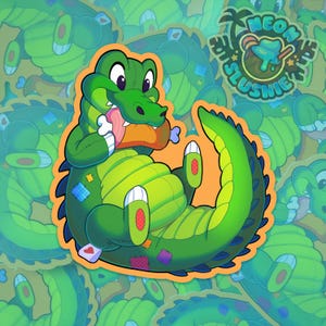 Peut inclure: Un autocollant de crocodile vert de style dessin animé avec une texture en peluche et des patchs colorés, mangeant un morceau de viande avec un os. Le logo en haut à droite affiche Neon Slushie avec un palmier et une icône de granité fondant.