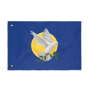 May include: A blue flag featuring a white dove with outstretched wings, holding a green olive branch, set against a yellow circle resembling the sun. The flag has grommets for hanging.