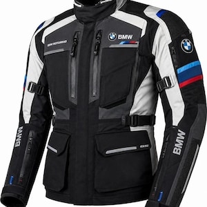 Może przedstawiać: Czarno-szaro-biała kurtka motocyklowa z logo BMW na piersi i rękawach. Kurtka posiada liczne kieszenie zapinane na zamek, regulowane paski w talii oraz niebiesko-czerwone paski ozdobne na ramionach z napisem BMW Motorrad.