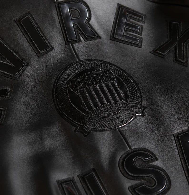 Detailed close-up shot of premium black lambskin leather material showing the soft grain texture, precision stitching, and heavy-duty zipper.
