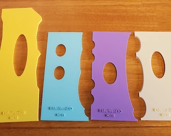 May include: Set of six colorful plastic stencils with different shapes and sizes. The stencils are designed for crafting and decorating projects.