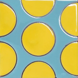 May include: A blue tile with a pattern of yellow circles and half circles.