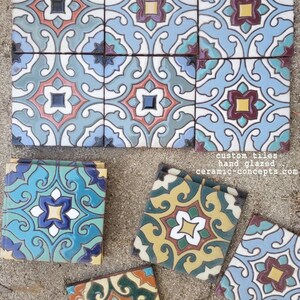 Op de afbeelding: Handgeglazuurde, op maat gemaakte keramische tegels met ingewikkelde bloemen- en geometrische patronen in tinten blauw, blauwgroen, geel en rood. De tegels zijn gerangschikt in een raster en verspreid. Tekst op de tegels luidt: custom tiles hand glazed ceramic-concepts.com.