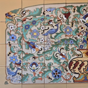 May include: A decorative tile with a floral pattern featuring peacocks, leaves, and flowers in shades of blue, green, yellow, and white on a beige background.