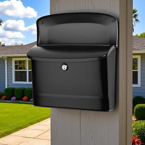 Puede incluir: Un buzón negro montado en la pared con una parte superior curvada y una cerradura. El buzón está montado en un poste de madera, con una casa y jardinería visibles en el fondo. El buzón es de metal.