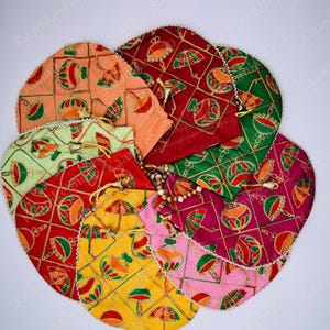 May include: A collection of colorful, embroidered drawstring pouches. The pouches are in various colors, including red, green, yellow, pink, and orange. Each pouch features a repeating pattern of umbrellas and other decorative elements, outlined in gold thread.