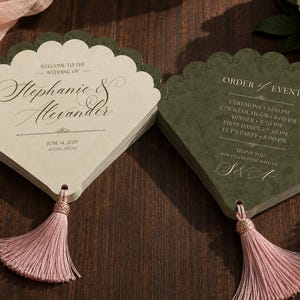 Könnte beinhalten: Zwei fächerförmige Hochzeitsprogramme mit gewelltem Rand und rosa Quasten. Eines ist cremefarben mit schwarzem Text Stephanie & Alexander, June 14, 2029, Austin, Texas. Das andere ist dunkelgrün mit schwarzem Text zum Ablauf der Veranstaltung.