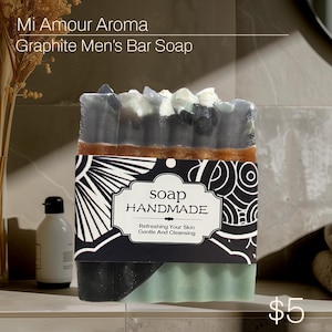 May include: A bar of black and green soap with a brown and white label that says "soap handmade refreshing your skin gentle and cleansing".