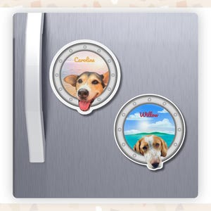 A fridge with two custom porthole magnets featuring dogs with their heads hanging over the edge. One is called Caroline and the other is called Willow.