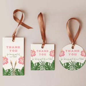 May include: Three gift tags with brown ribbon. The tags are white with pink text that reads "THANK YOU for being part of our tribe!" and feature pink hibiscus flowers and green tropical leaves.