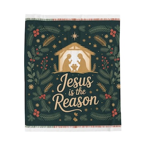 May include: A dark green Christmas blanket with a festive design. The blanket features a nativity scene in gold, surrounded by evergreen branches, red berries, and stars. The text "Jesus is the Reason" is written in gold.