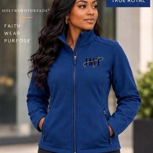 May include: A true royal blue softshell jacket featuring a high collar, a full-length front zip, and two zipped side pockets. The chest displays the embroidered letters HWT in a stylised font. Text on the image reads HOLYWORDTHREADS FAITH WEAR PURPOSE.