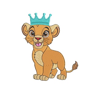 May include: An embroidered design of a cartoon lion cub wearing a teal crown. The lion cub is tan with a pink tongue, brown eyes, and a small tail. The design is on a white background.