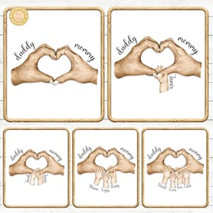 Puede incluir: Un conjunto de cinco impresiones enmarcadas con fondo blanco. Cada impresión presenta una forma de corazón formada por manos, con las palabras "papá" y "mamá" arriba. Algunas impresiones incluyen manos de niños y nombres.