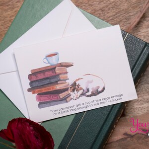 May include: A white card with a watercolor illustration of a cat sleeping on a stack of books with a cup of tea on top. The card has a quote from C.S. Lewis: "You can never get a cup of tea large enough or a book long enough to suit me."