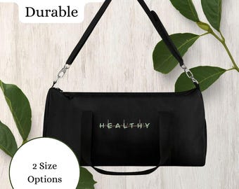 May include: Black duffel bag with a shoulder strap and the word "HEALTHY" embroidered in green and white. The bag has the text "Lightweight & Durable" and "2 Size Options" in the image.