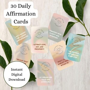 Puede incluir: Un conjunto de 30 tarjetas de afirmaciones diarias con fondos pastel y mensajes inspiradores. Cada tarjeta presenta "Elevate Your Everyday" y afirmaciones como "Atraigo amor, alegría y prosperidad."