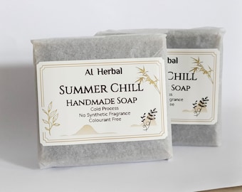 May include: Two bars of handmade soap, wrapped in gray paper, with labels that read "Summer Chill" and "Al Herbal." The labels feature botanical illustrations and text indicating a cold process, fragrance-free soap.