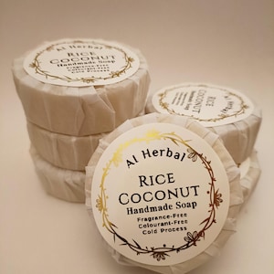 May include: Several handmade rice coconut soaps wrapped in white paper. Each soap has a gold label with the text "Al Herbal Rice Coconut Handmade Soap". The soaps are fragrance-free, colourant-free, and cold processed.