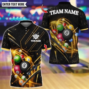 Può includere: Polo nero a tema biliardo. La maglietta presenta un design di palle da biliardo, accenti dorati e la scritta "TEAM NAME" sul retro. La parte anteriore include la scritta "ENTER TEXT HERE" e "YOUR NAME".