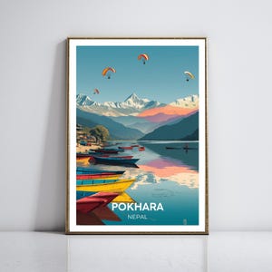 Póster de viaje de Pokhara, Nepal: la cordillera del Annapurna reflejada en el lago Phewa. Decoración de pared vibrante y aventurera con parapentes y barcos.