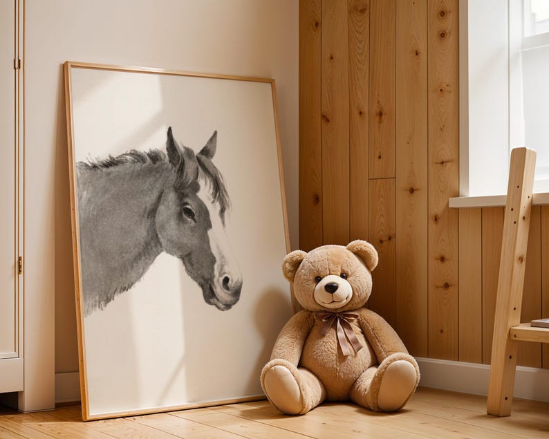 May include: A framed watercolor print of a horse's head in shades of gray and white. A large, plush teddy bear with a brown ribbon sits next to the artwork. The room has wooden paneling and a small wooden ladder.