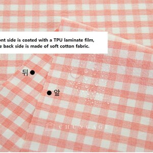 May include: Close-up of a pink and white gingham fabric. The front side is coated with a TPU laminate film, and the back side is made of soft cotton fabric. The text "428 진핑크" is in the bottom right corner.