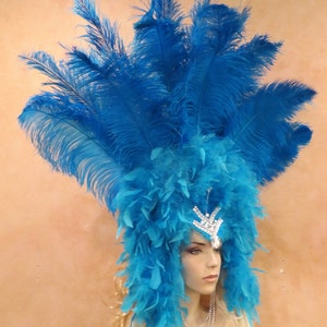 K&ouml;nnte beinhalten: Ein blauer Federkopfschmuck mit einer Strasskrone. Der Kopfschmuck besteht aus langen, flie&szlig;enden Federn und ist perfekt f&uuml;r ein Kost&uuml;m oder eine Party.