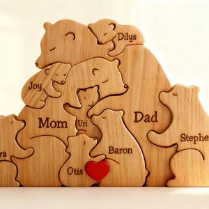 Peut inclure: Puzzle familial en bois représentant des ours. Le puzzle comprend des noms tels que « Maman » et « Papa », ainsi que d'autres membres de la famille, avec un détail de cœur rouge. Un cadeau personnalisé charmant.