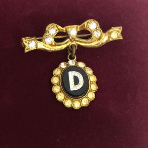 Broche vintage dorado con la letra "D" de los años 50