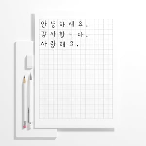 May include: A white notepad with a grid pattern and Korean text. The words "안녕하세요, 감사합니다, 사랑해요" are written in black. A white eraser, a yellow pencil, and a white pencil are on the left.