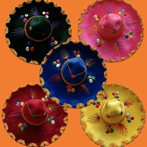 May include: Five sombreros in black, pink, blue, red, and yellow. Each hat features a wide brim with gold braided trim, a conical crown, and decorative embroidery in radiating patterns. Small, colourful sequins are scattered across the surface.