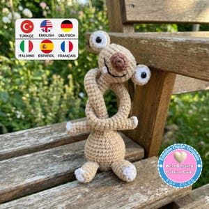 May include: A crocheted beige alien-like creature with large eyes, a smiling mouth, and a knotted neck. The creature has white accents on its feet and hands. The image includes text in a circle that says "Editable Digital Template" and "Best Detailed Pattern Guide".