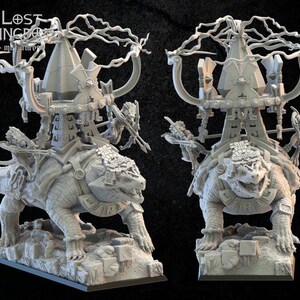 May include: A detailed, grey miniature of a fantasy creature, possibly a dinosaur or turtle, carrying a structure with archways and a tree-like element. The miniature is on a base, with two identical models side-by-side.