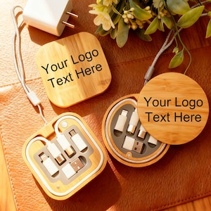 Puede incluir: Un kit de carga de madera con el texto "Your Logo Text Here" en la tapa. El kit incluye un cargador blanco, una funda cuadrada y una funda redonda, todos con un acabado de madera clara. Las fundas contienen varios cables de carga.
