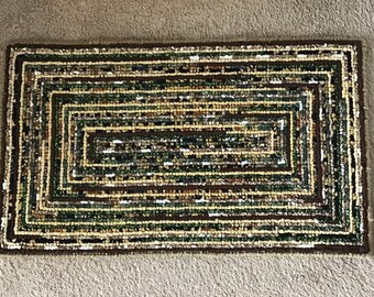 Area rug locker hooked in neutral greens, yellow, brown and more
