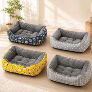 May include: Four rectangular pet beds with high, cushioned walls and a soft, tufted grey interior. The exterior patterns include a dark blue circular print, a light grey star print, a bright yellow dog print, and a grey grid pattern.