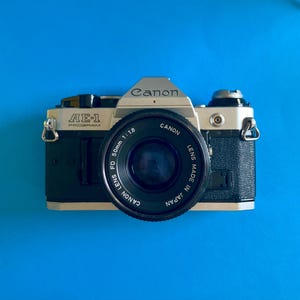 Könnte beinhalten: Ein Set aus drei Keramikbechern mit gesprenkelter, matter Oberfläche. Die Becher sind in Creme-, Hellgrau- und Dunkelgrautönen gehalten. Jede Tasse hat ein schlichtes, minimalistisches Design, ideal für Kaffee oder Tee.