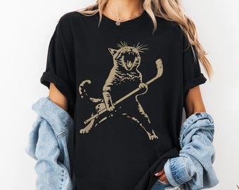 Katze beim Eishockey (SVG), Lustige Katzensport-Grafik (PNG), Niedliche Winterhockey-Cliparts, Tierhumor-Grafik, Design einer sportlichen Katze, PNG- und SVG-Datei