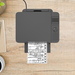May include: A gray printer is printing a black and white puzzle featuring cartoon illustrations of Roman soldiers. The puzzle pieces are labeled with letters. The printer sits on a wooden surface, with a pen and notepad visible.