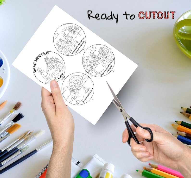 May include: A white sheet of paper with four circular illustrations, each depicting a scene from a biblical story, held by a person. The text "Ready to CUTOUT" is at the top. Scissors are cutting the paper. Paintbrushes and colored pencils are in the background.